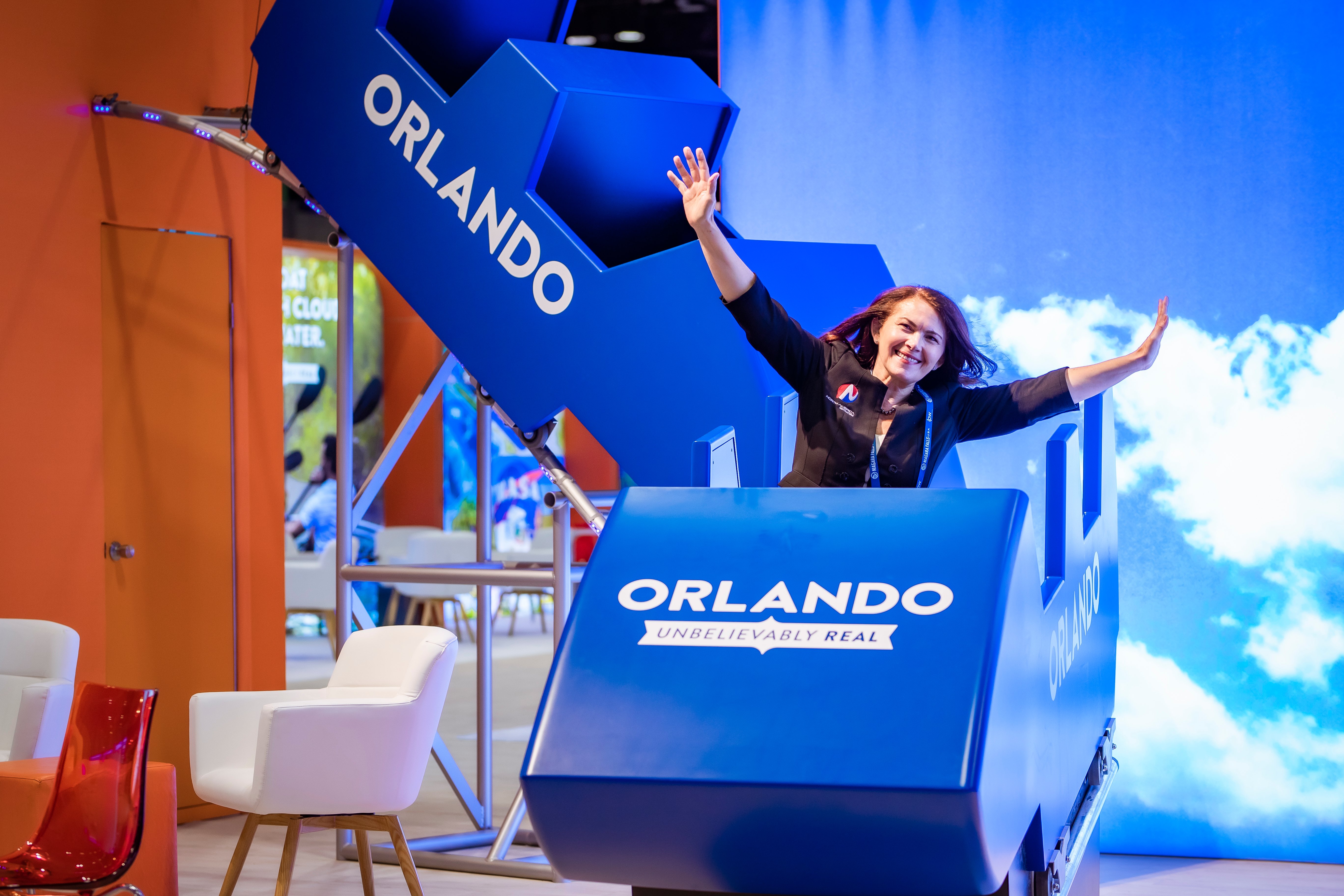 Two white women pose with their hands up at a blue  rollercoaster photo op . 